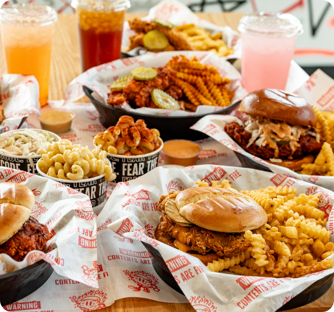 Birdcode food spread with chicken, fries, sauces, and drinks